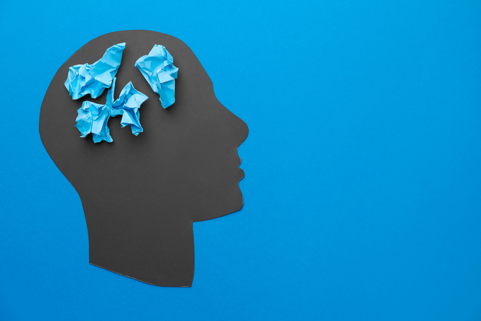 Human Head and Crumpled Papers on Color Blue Background